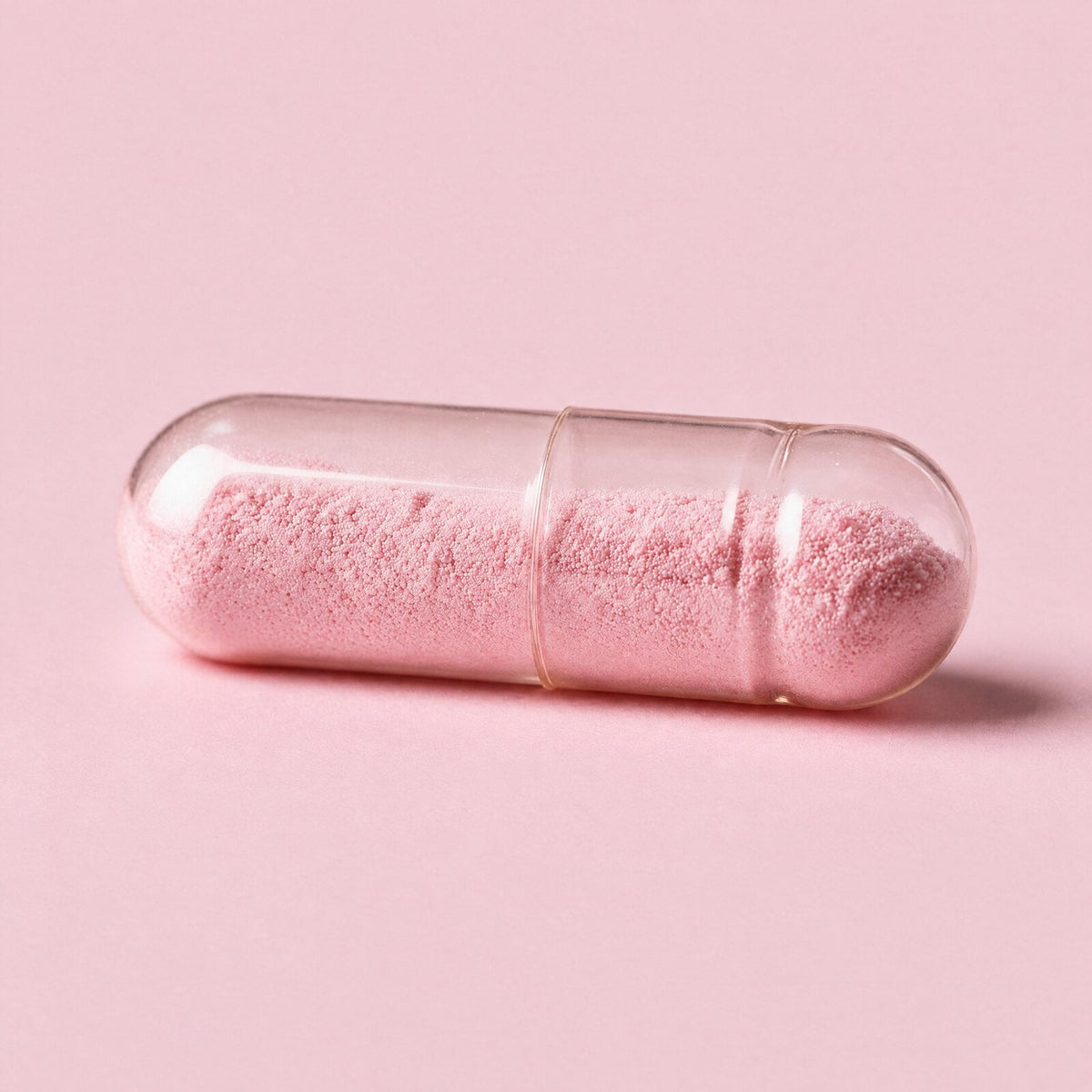 Cápsula transparente con polvo rosado de arándano rojo, sin colorantes